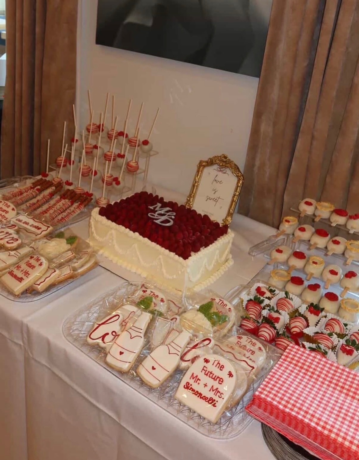 Dessert table with cake, cookies, strawberries, and cakepops